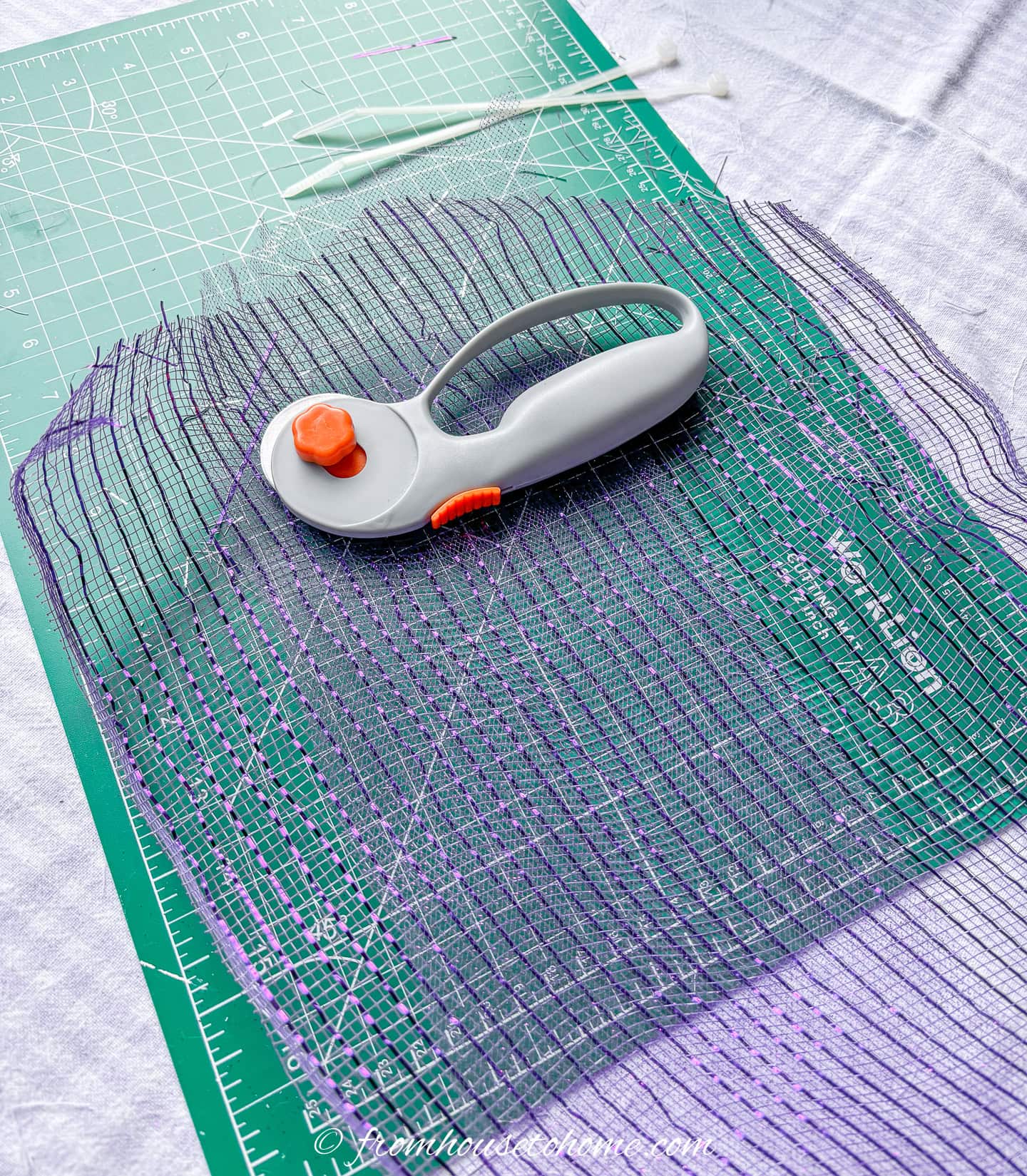 purple deco mesh, a cutting wheel, and zip ties on a craft mat