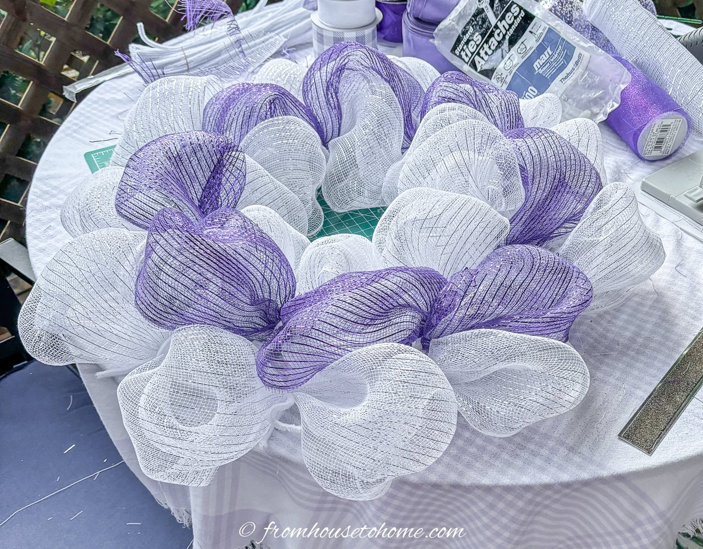 wire wreath form with white and purple deco mesh attached to it