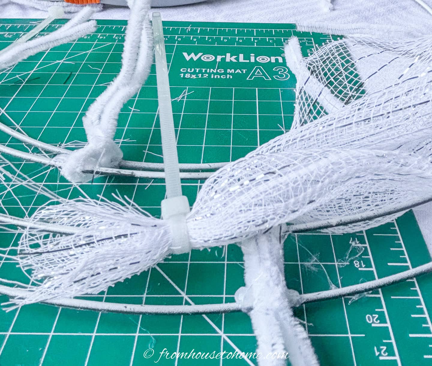 a zip tie attaching white deco mesh to a wreath form