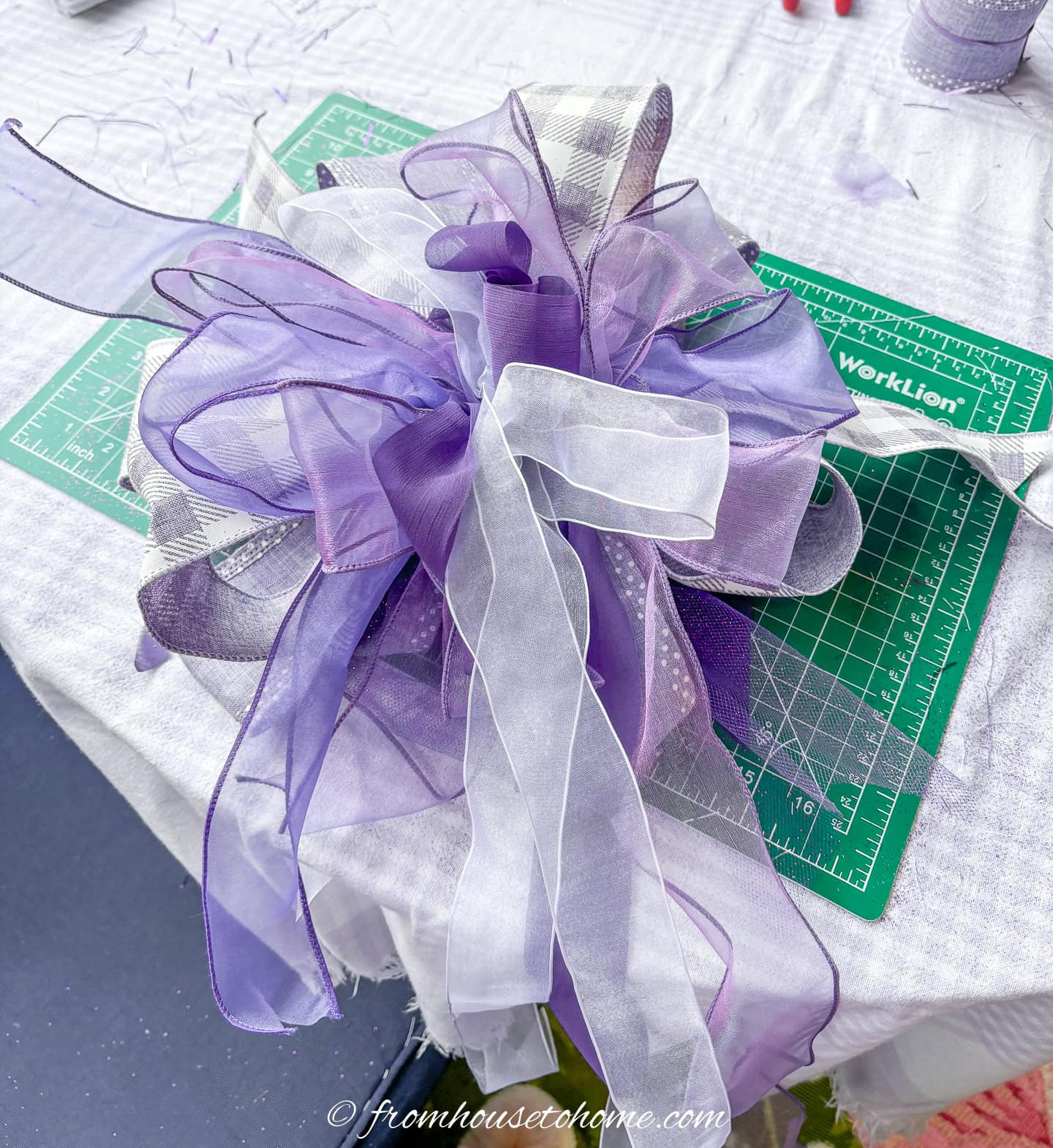 A purple and white bow after it has been made with the Bowdabra bow making machine