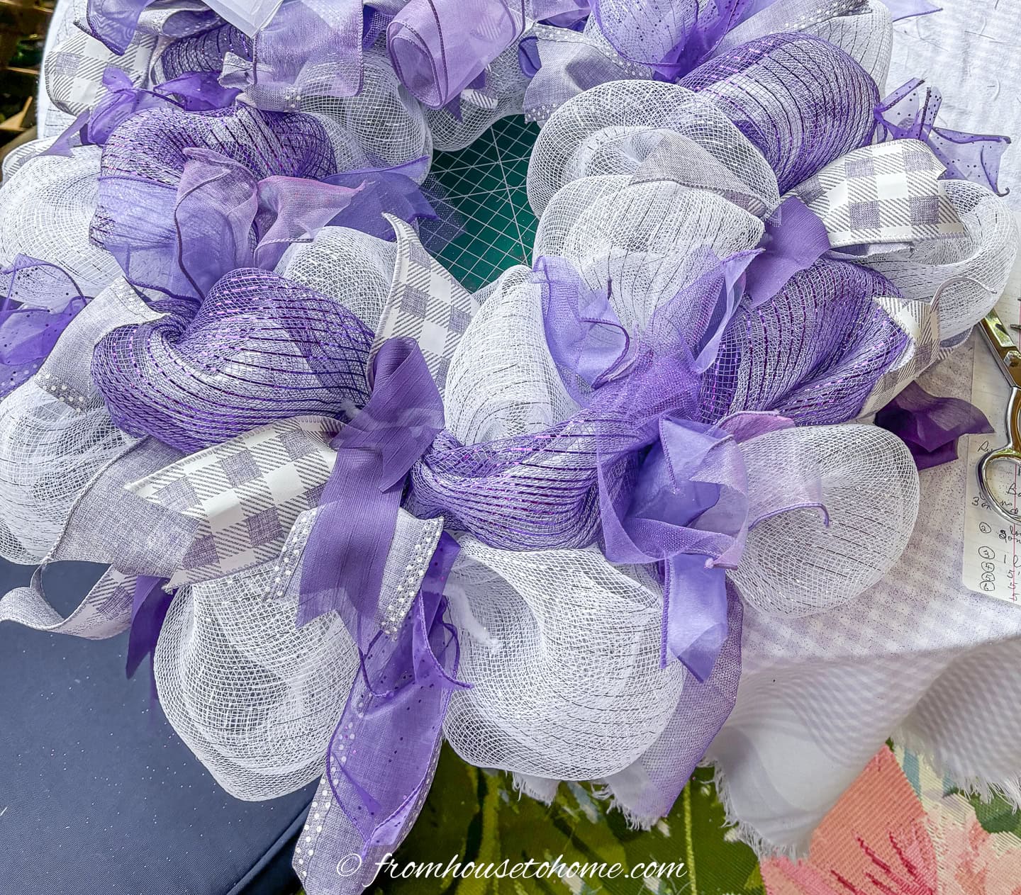 A purple and white bow on a lavender and white deco mesh pouf Christmas wreath