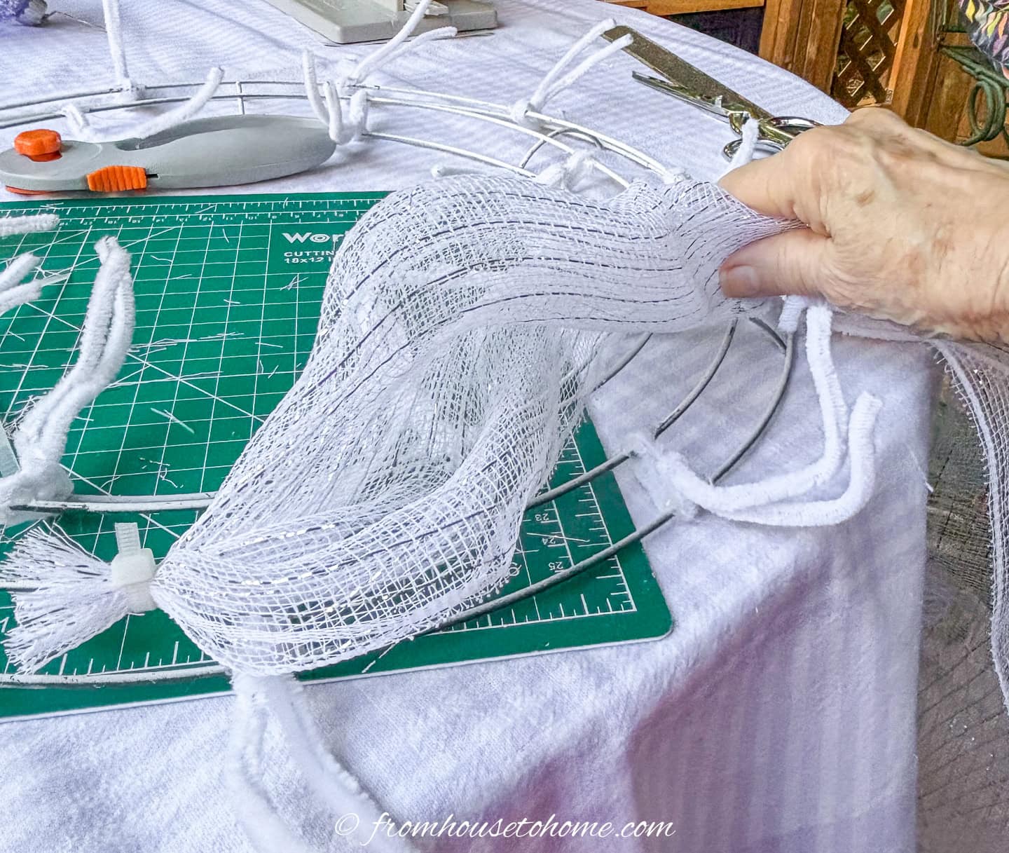 white deco mesh being measured against the wreath form