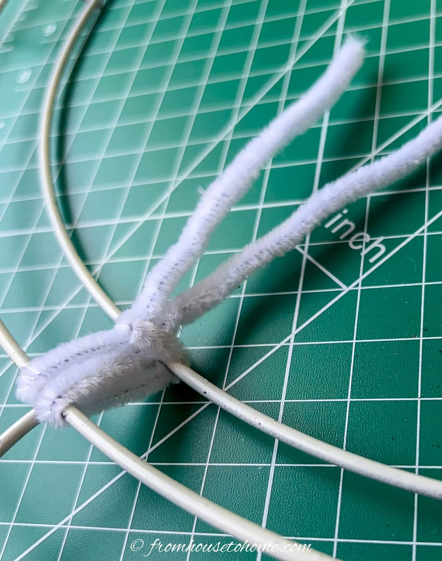 A pipe cleaner that has been attached to a wire wreath form