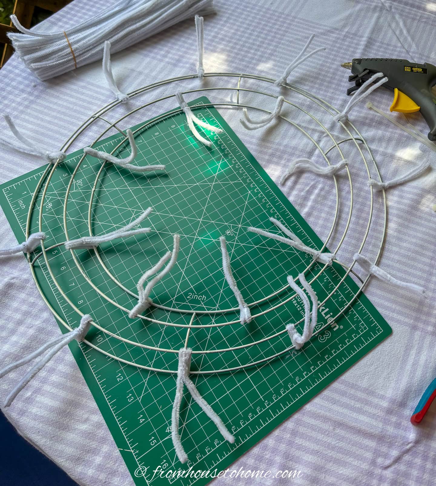 A wire wreath form with pipe cleaners attached around the inner and outer circles
