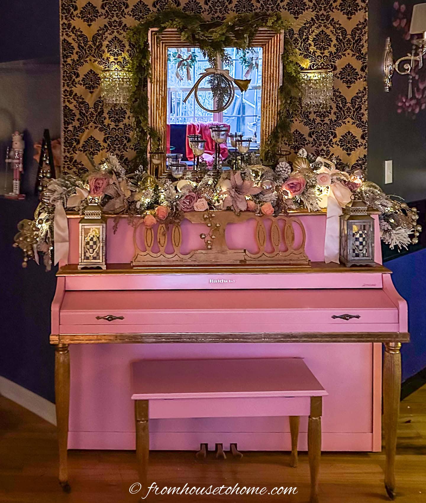 A pink piano with a pink and gold garland on top of it