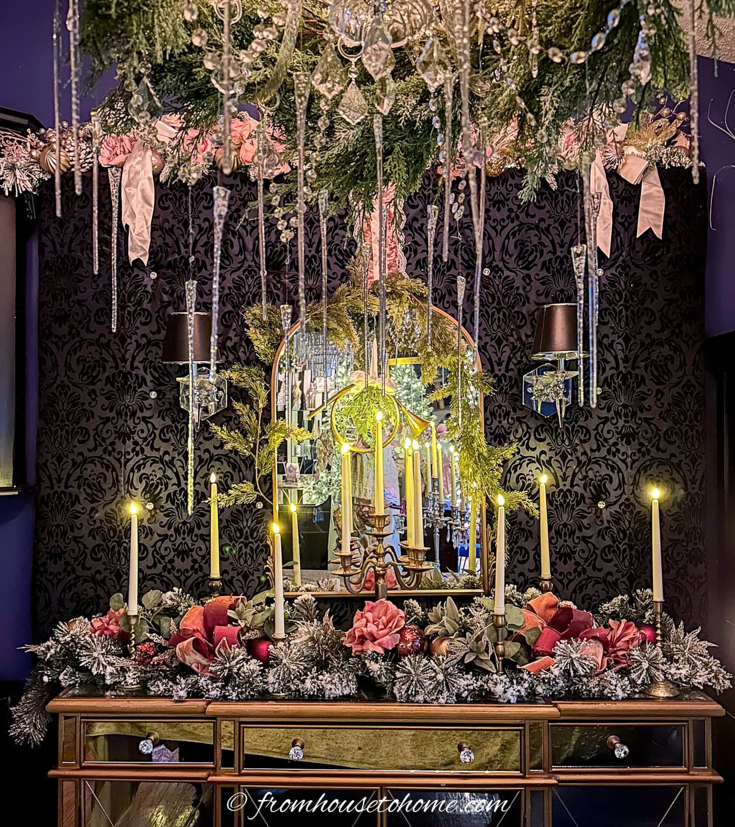 A buffet table decorated with pink and gold garland and lots of candles