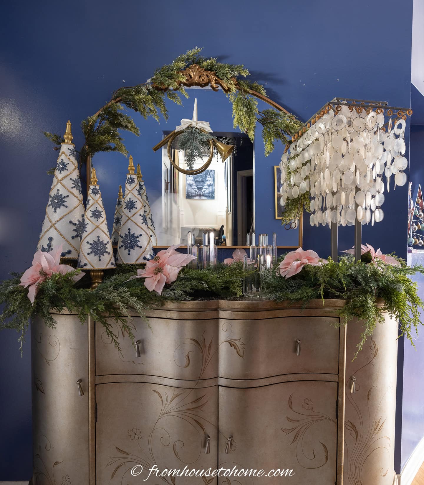 A front hall console table and mirro decorated with evergreen garland