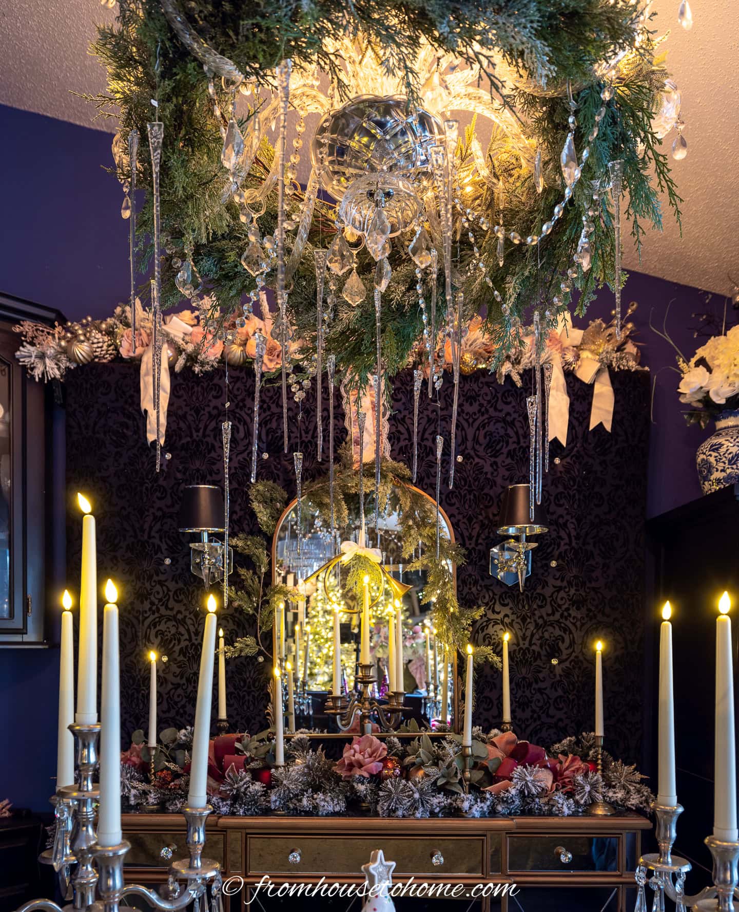 A chandelier decorated with evergreens and icicle ornaments