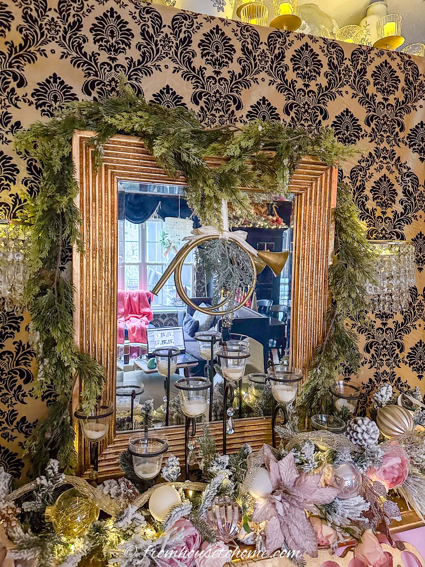 A mirror decorated for Christmas with evergreen garland