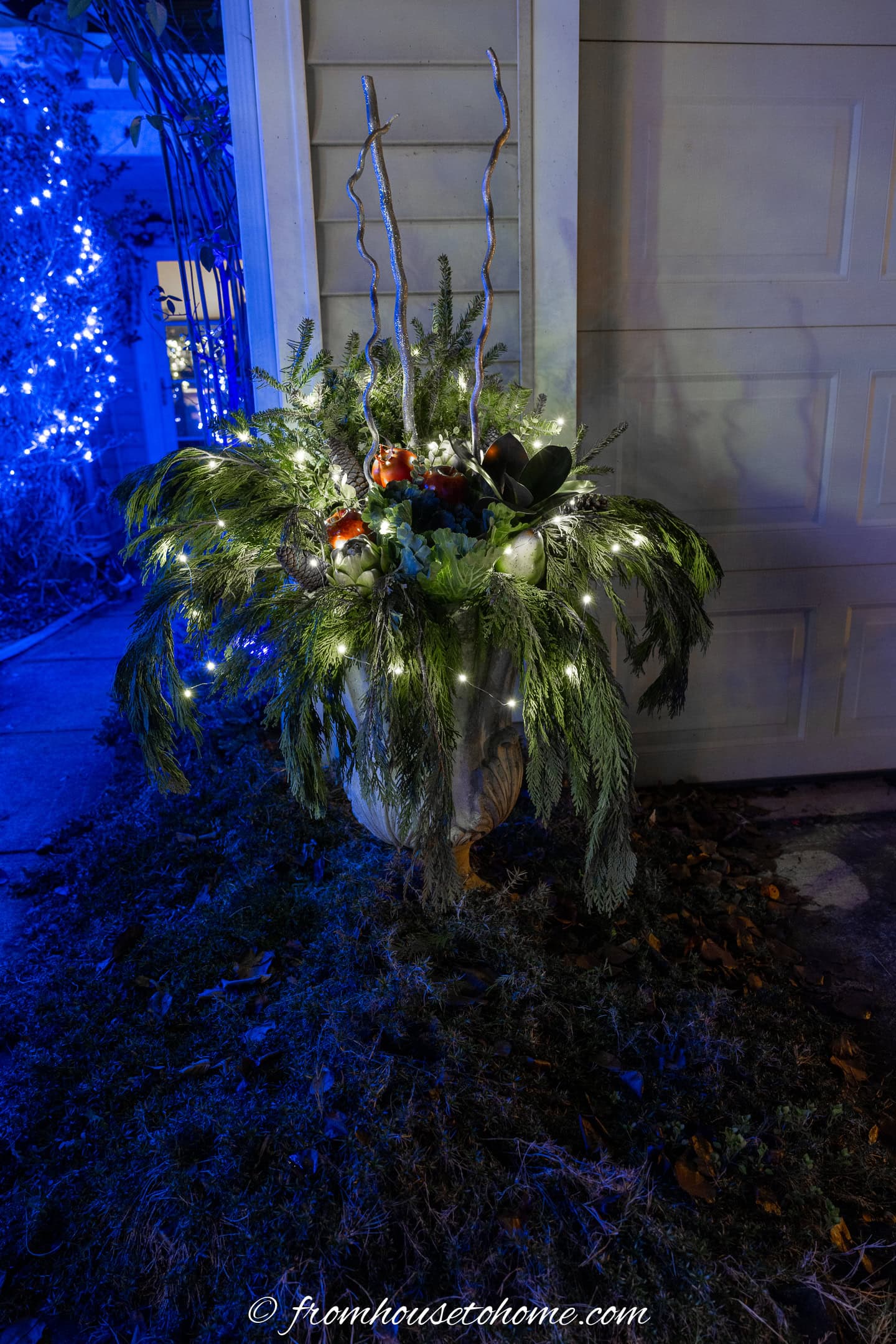An outdoor winter planter with fiary lights