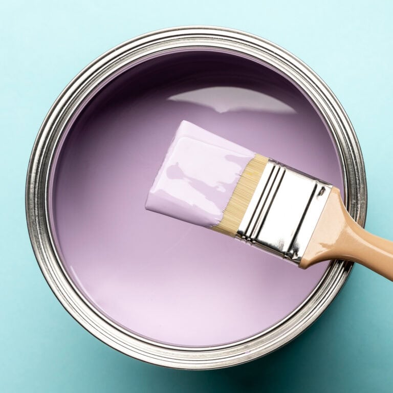 A bucket of purple paint on a teal background