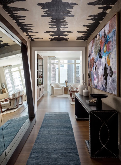 A hallway with dramatic black and white wallpaper on the ceiling