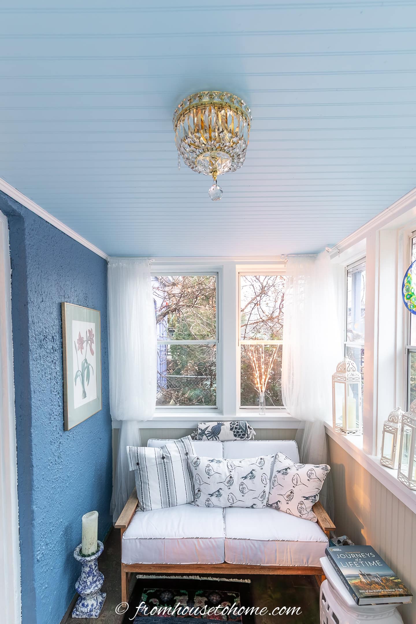 a small blue and white sun room with a light blue beadboard ceiling