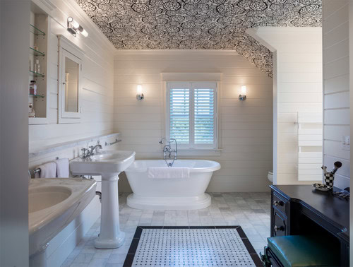 A white bathroom with black and white patterned wallpaper on the ceiling