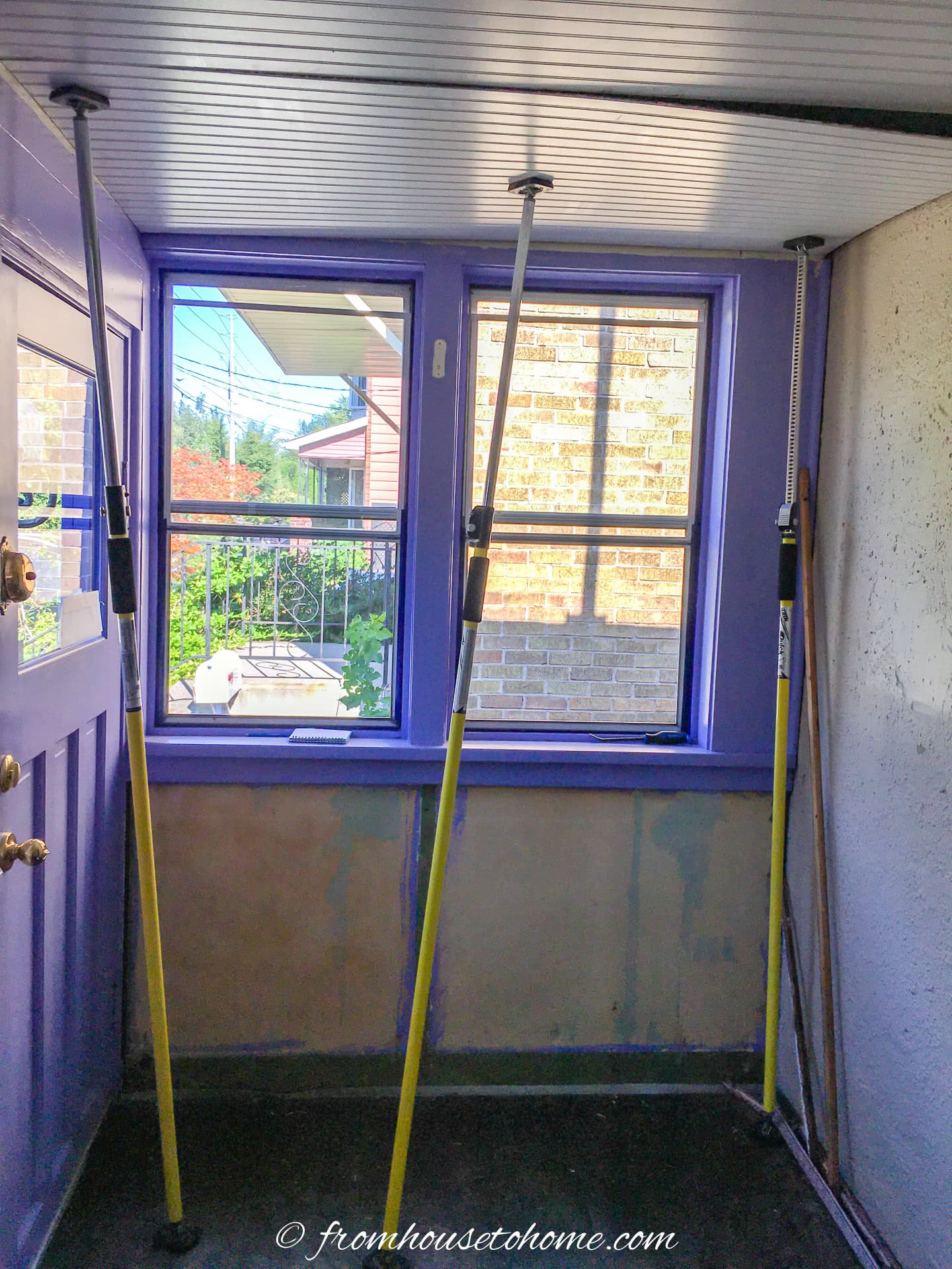 3 adjustable support poles holding up a piece of beadboard to the ceiling