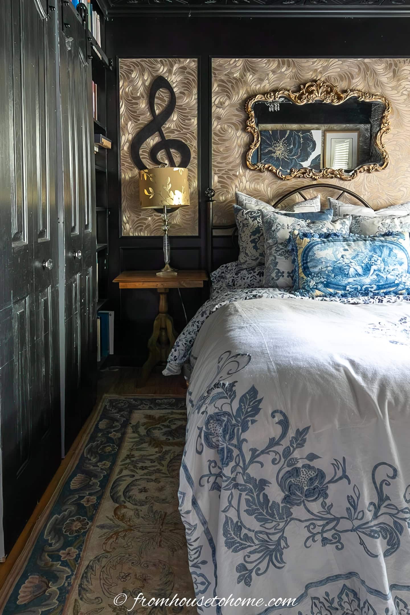 a simple bedside table with a lamp beside a bed with blue and white bedding