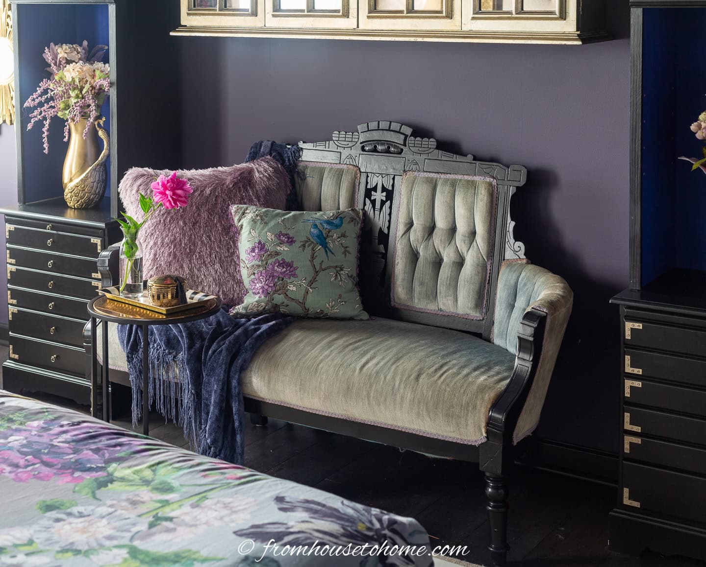 A green velvet settee in a bedroom