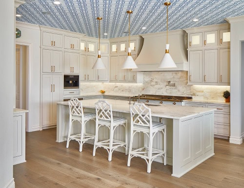 White kitchen with blue and white patterned wallpaper on the ceiling