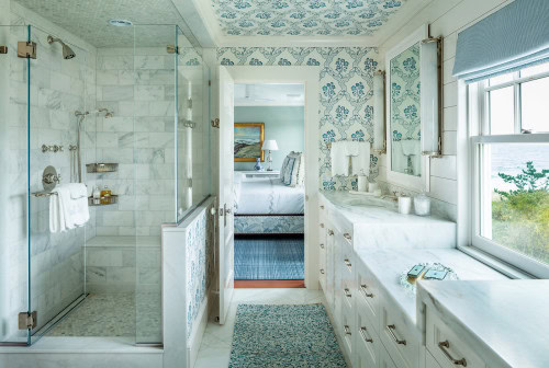 A coastal bathroom with the same blue and white wallpaper on the walls and ceiling