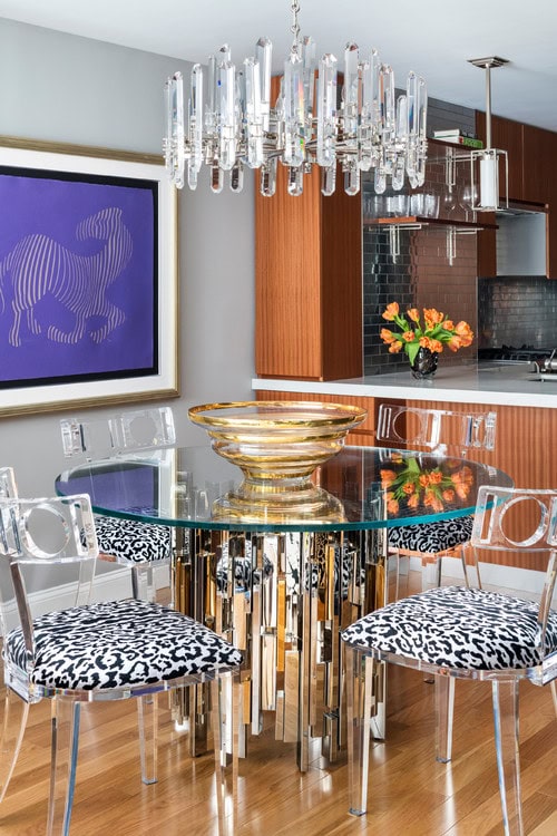 A dining room with a round table and a round chandelier over it