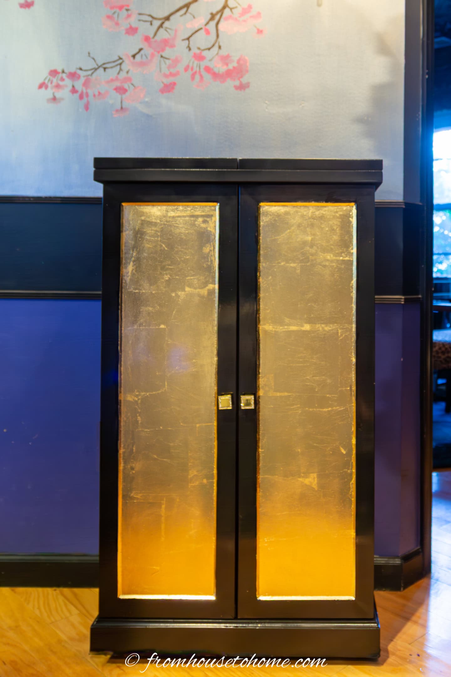 A black lacquer and gold bar cabinet