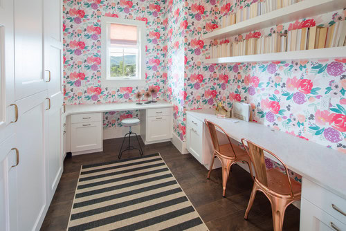 A home office with open bookshelves installed above the desk