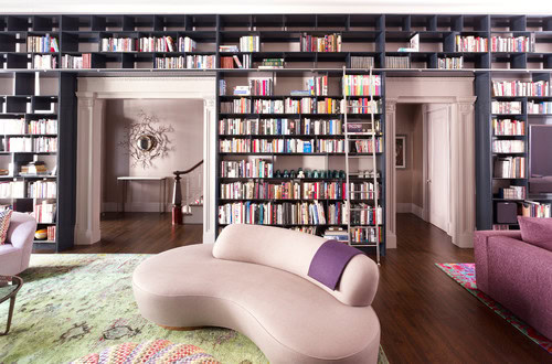 A wall library built over and around doors in a living room