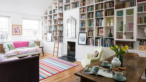 A wall library built around a fireplace in a living room