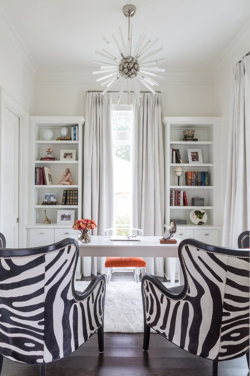 A black and white home office with bookcases installed on both sides of a window