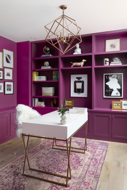 A home office with a purple library wall
