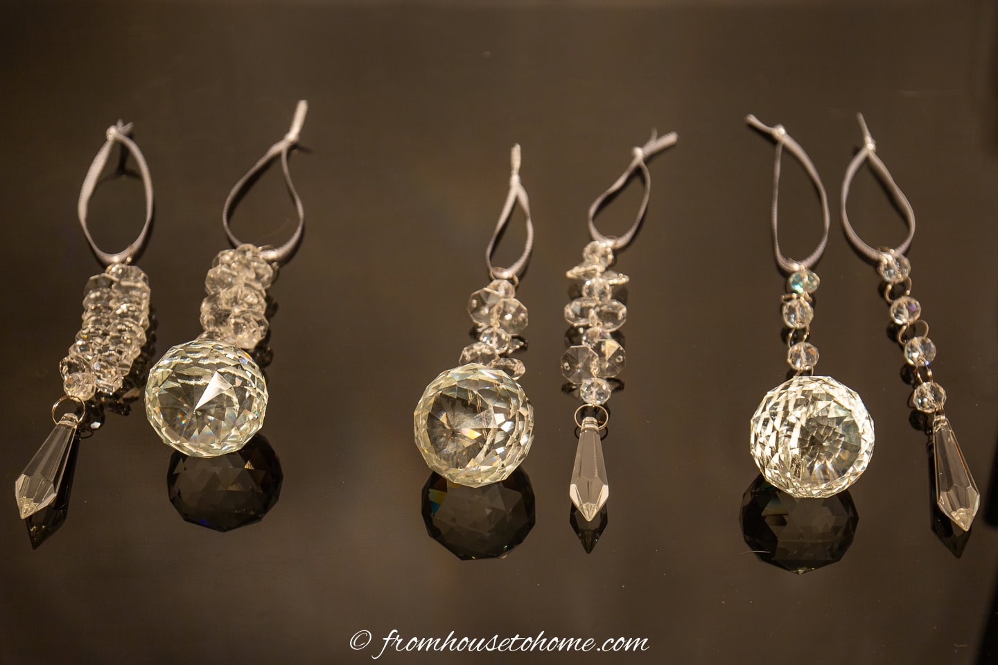 DIY crystal Christmas ornaments lying on a shiny black surface