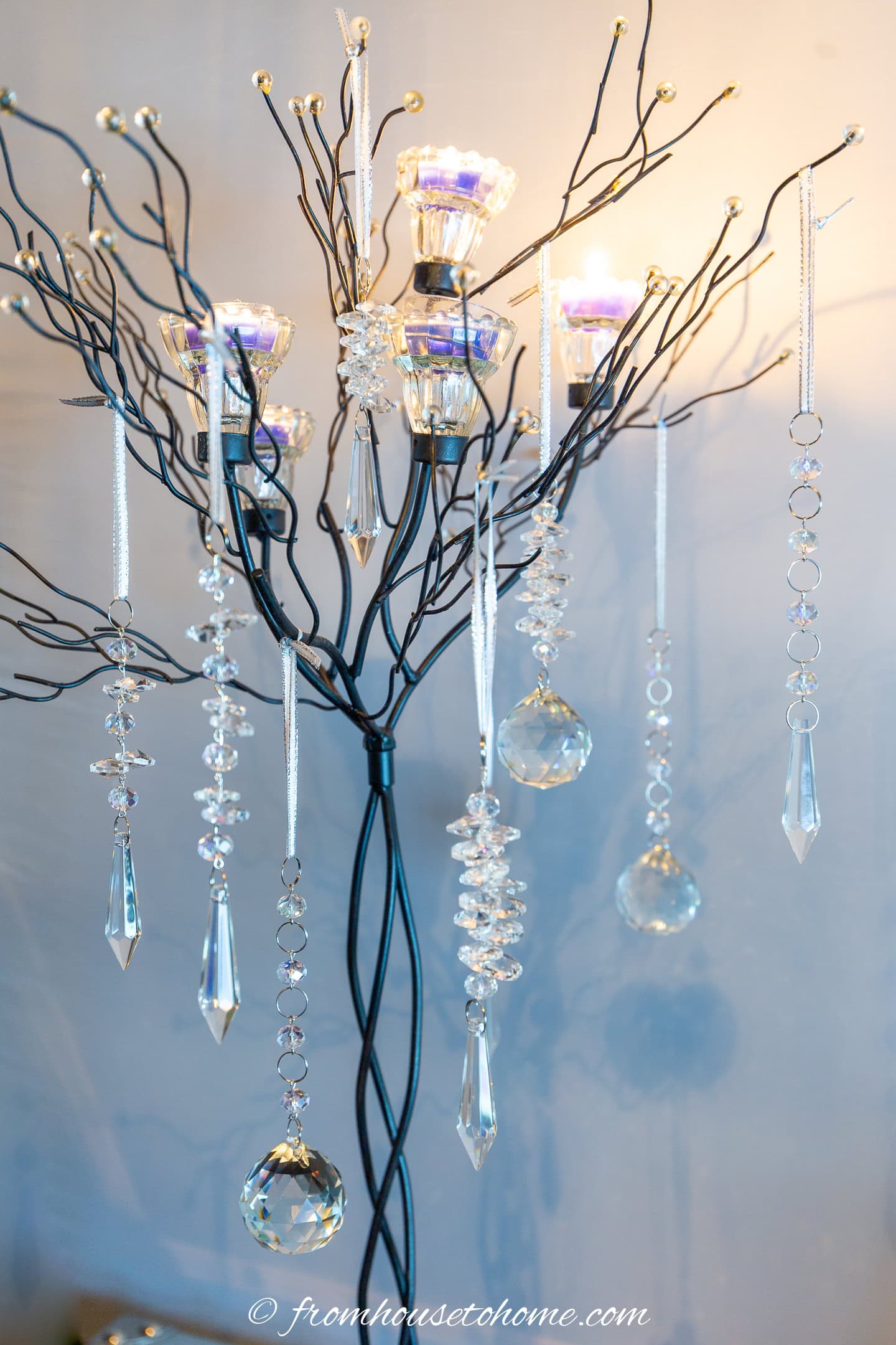 Crystal DIY Christmas ornaments hung from a candle tree with the candles lit