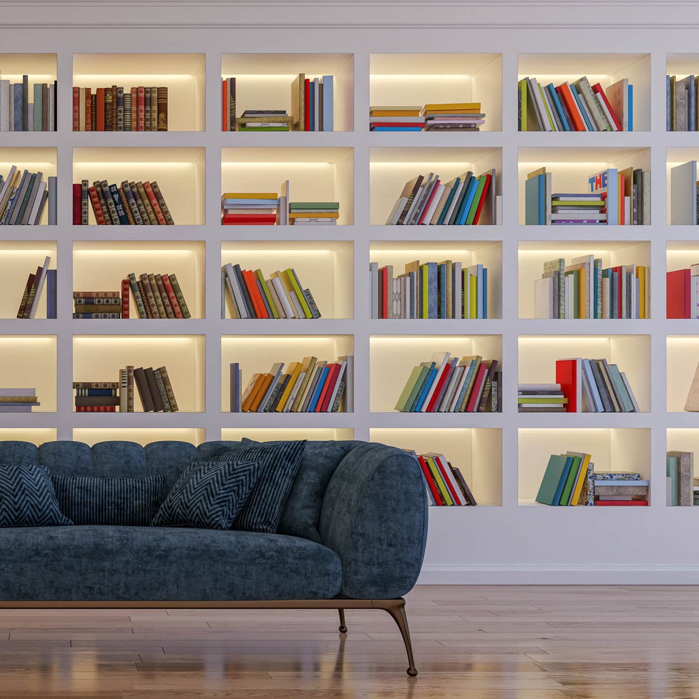 A blue sofa in front of a white bookshelf with lights behind the books