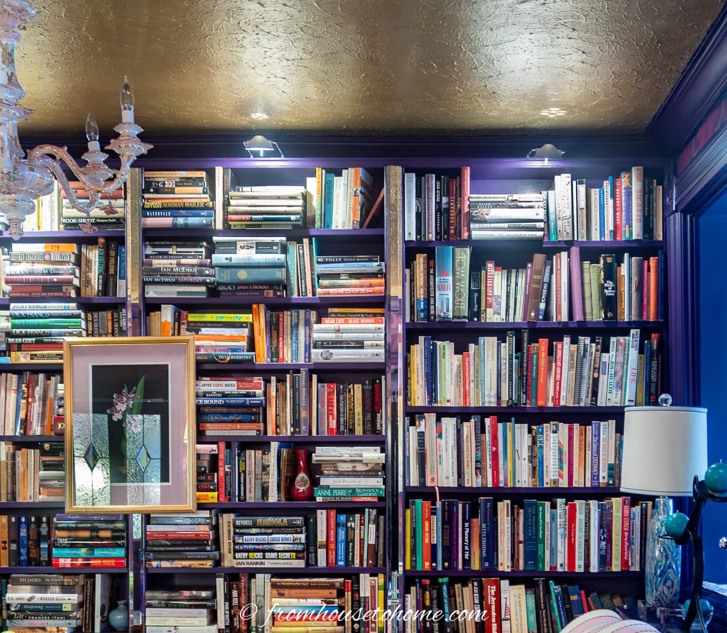 A bookshelf with lights installed at the top of it