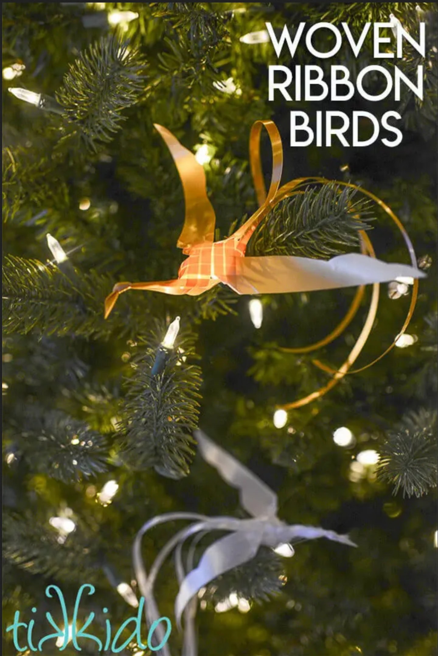 Orange and white woven ribbon birds hang on a lit Christmas tree, with the text