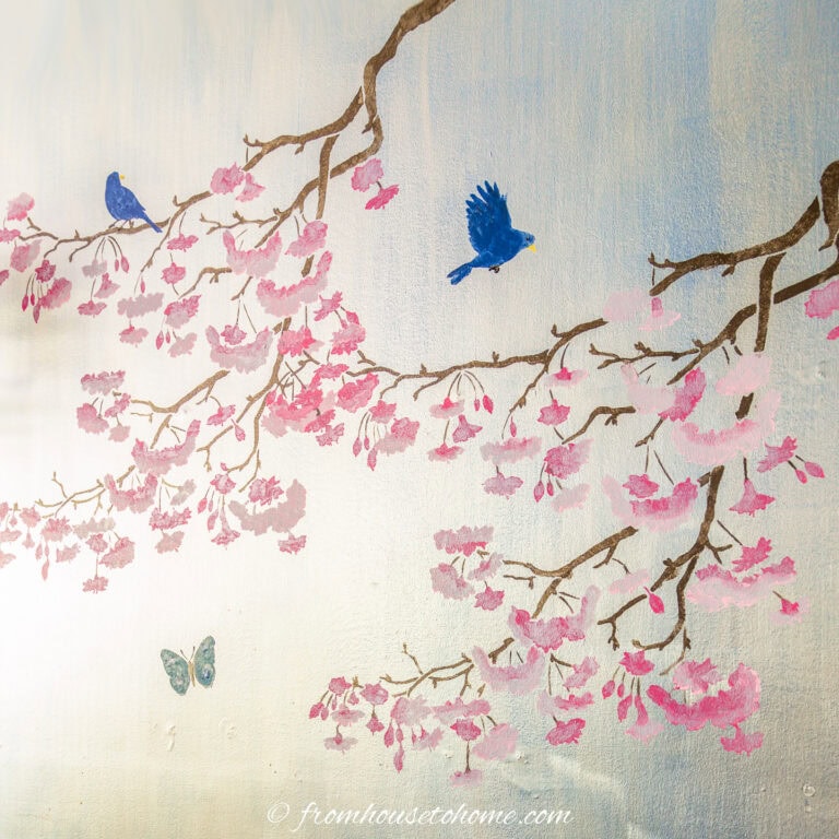 Two cherry blossom branches stenciled on a silver wall to make DIY Chinoiserie wallpaper