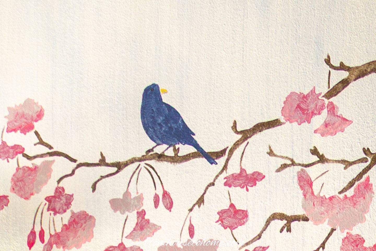 A blue bird painted onto a cherry blossom branch stencil on a silver wall