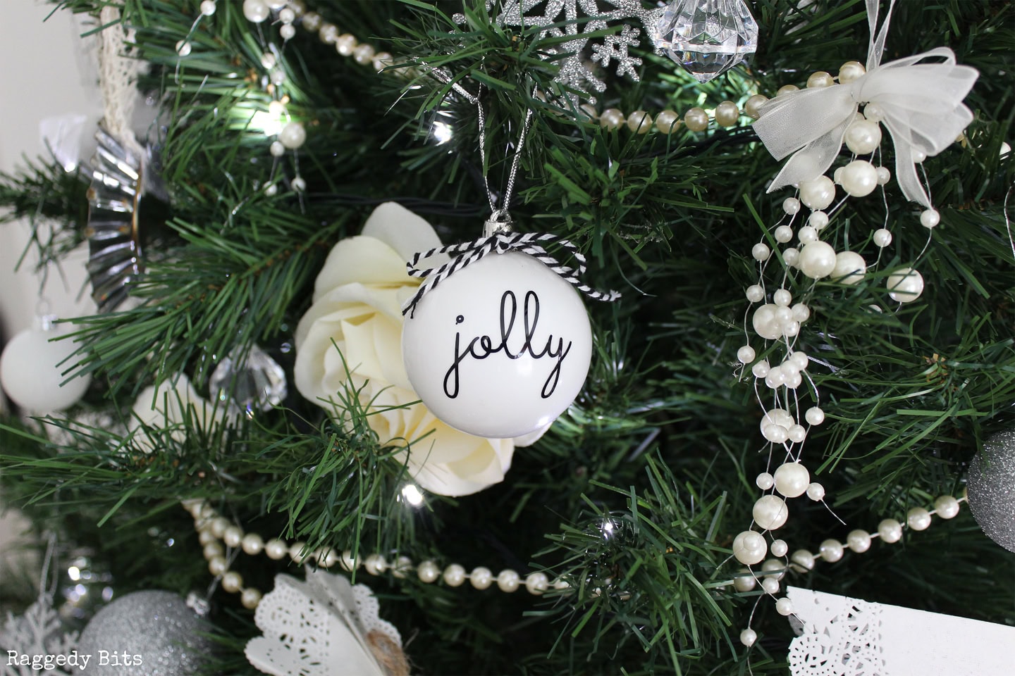 A decorated Christmas tree featuring a white ornament with the word