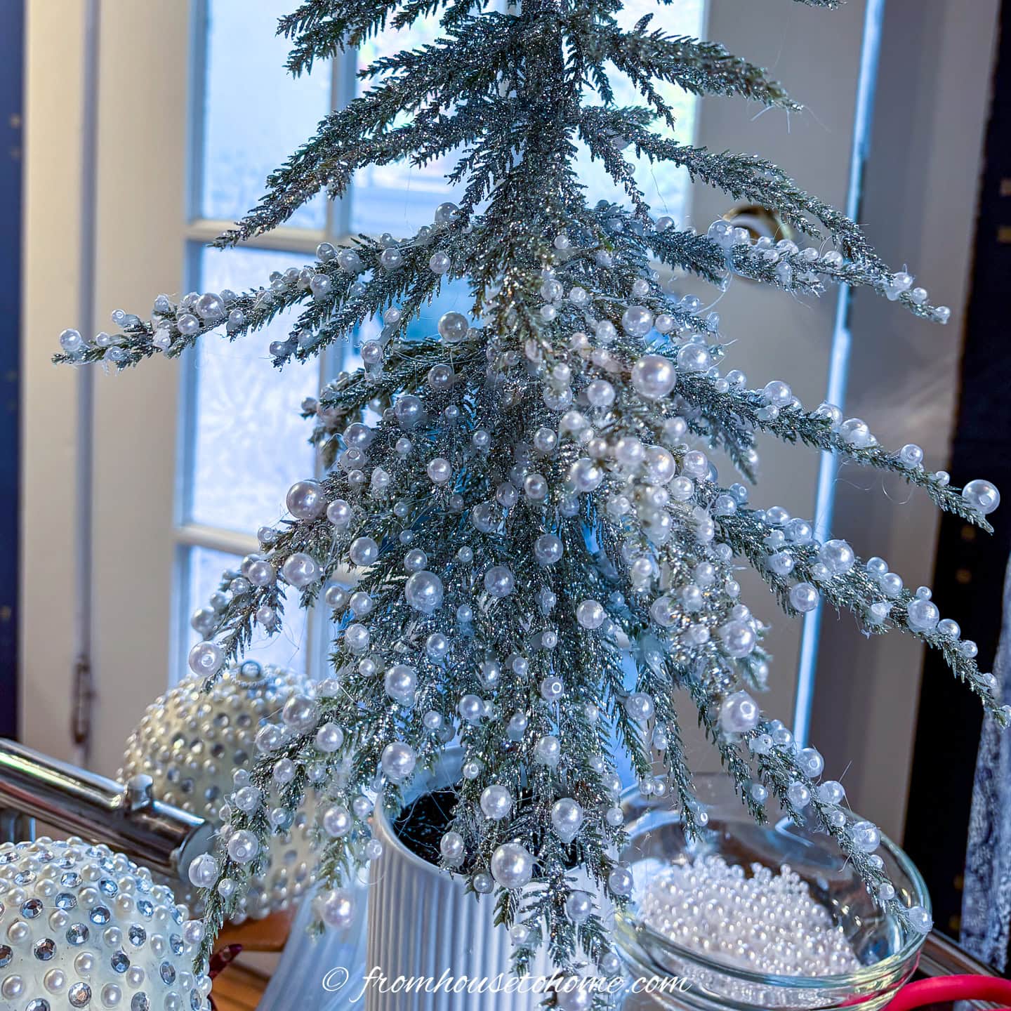 The bottom half of a tabletop Christmas tree covered with pearls