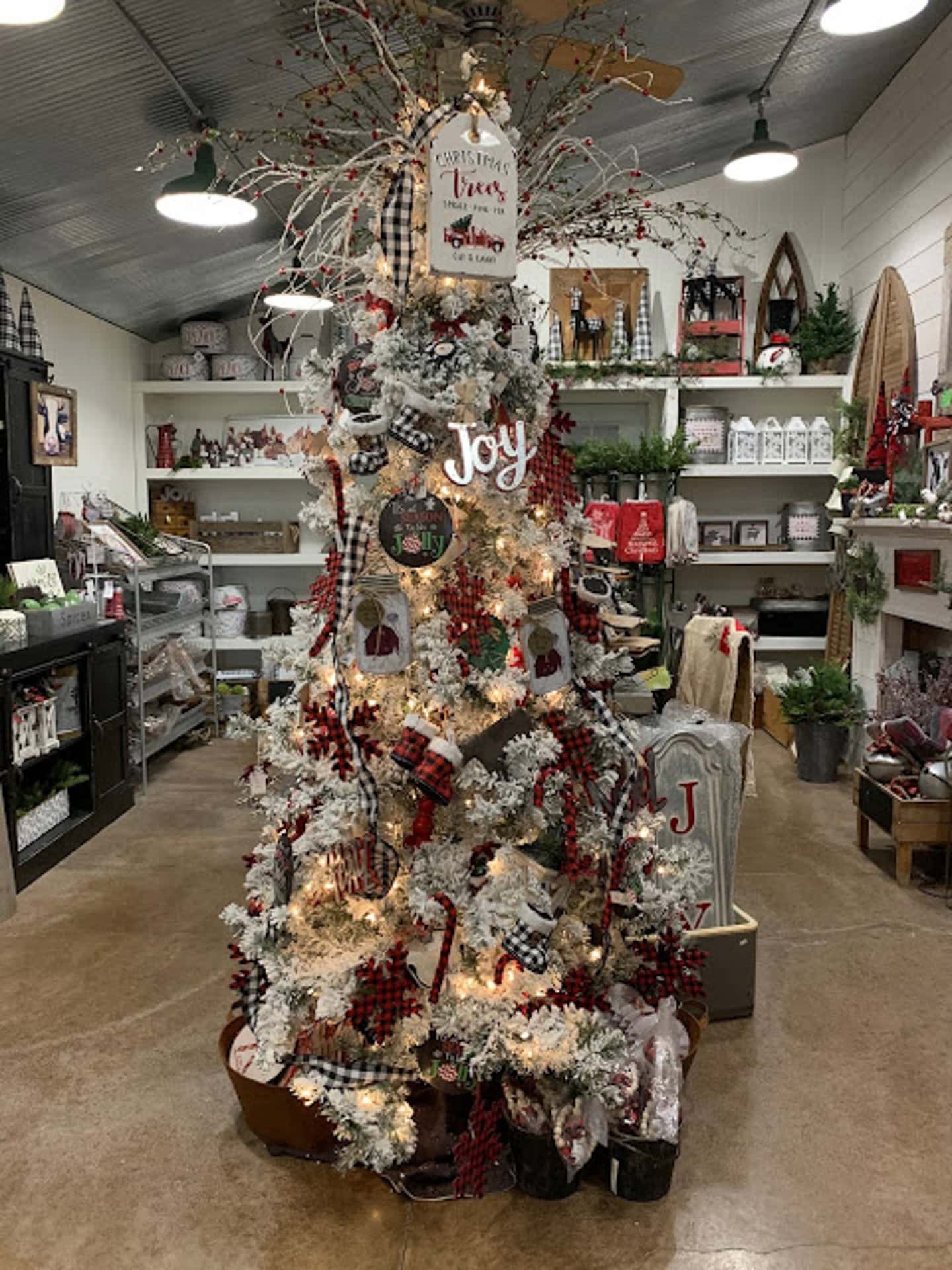 A decorated Christmas tree with white and red ornaments, plaid accents, and a