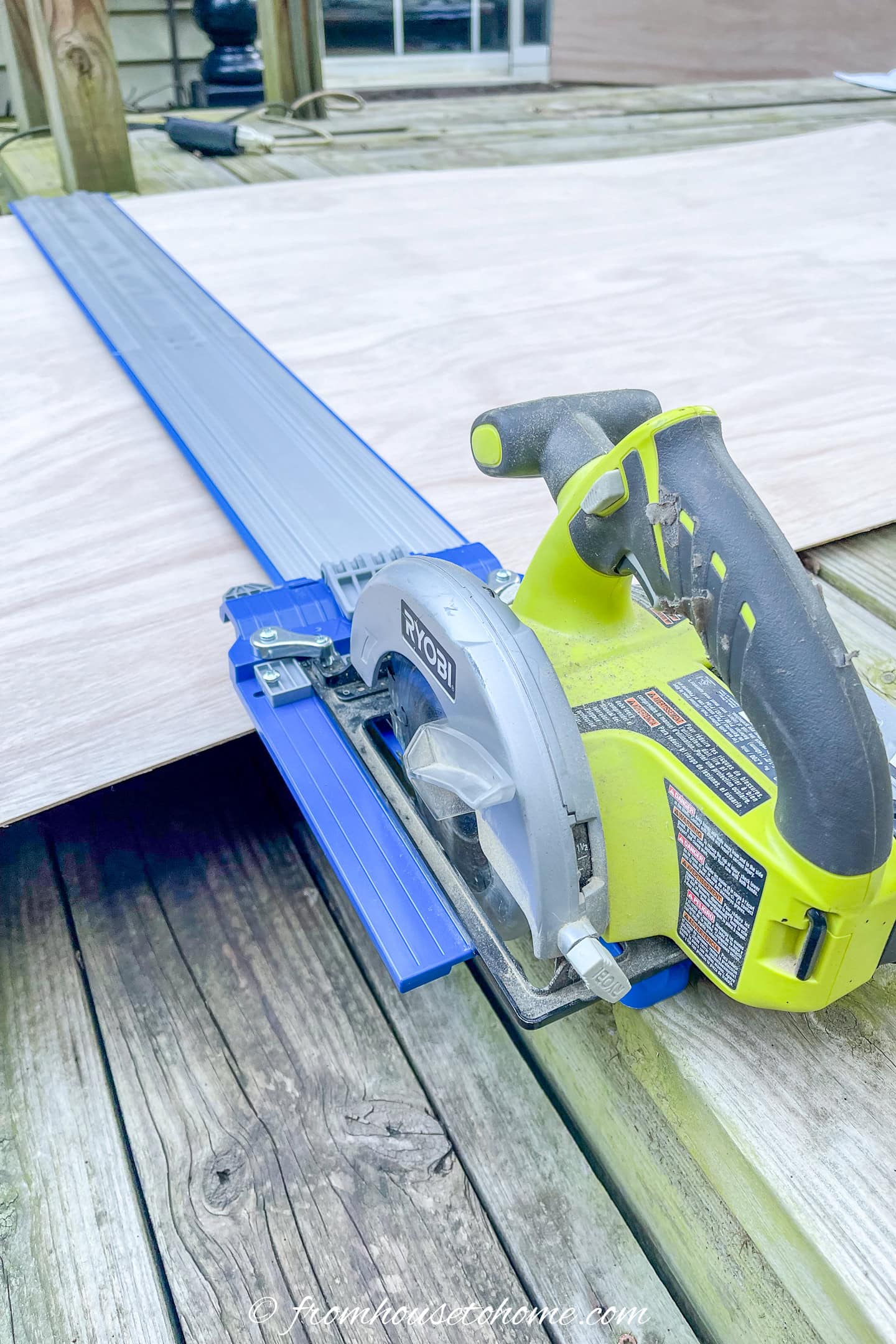 A cordless circular saw using a circular saw track to cut a 4' x 8' sheet of plywood