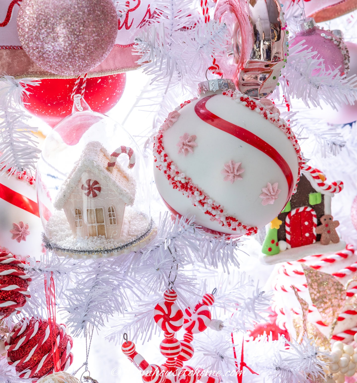 close up of red, white and pink ornaments on a candyland Christmas tree