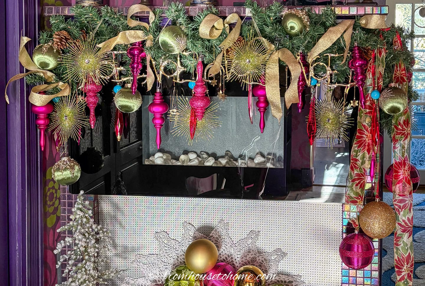 Christmas garland decorated with fuchsia and gold ornaments and ribbon on a fireplace mantel