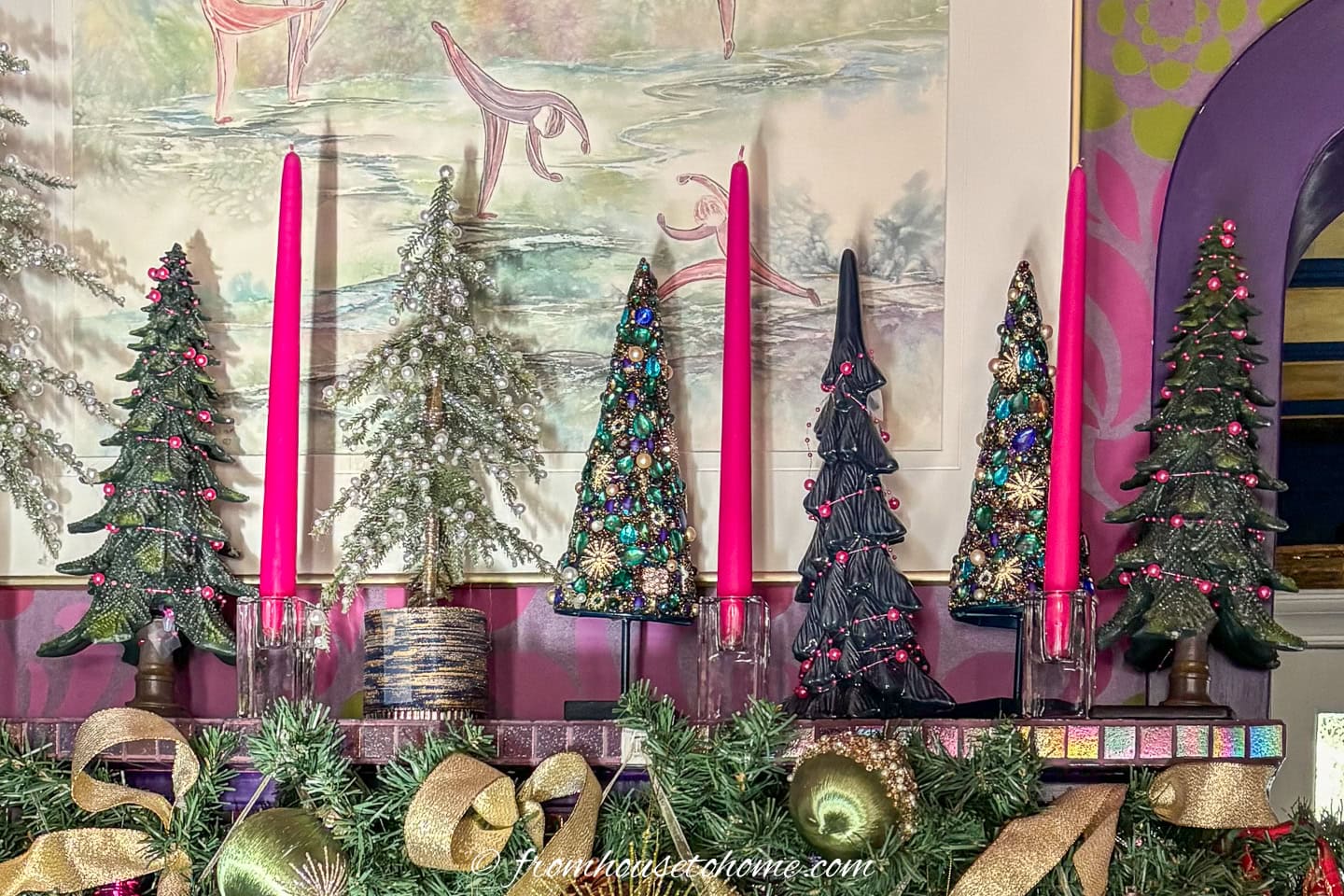 Mini Christmas trees and candles on top of a fireplace mantel