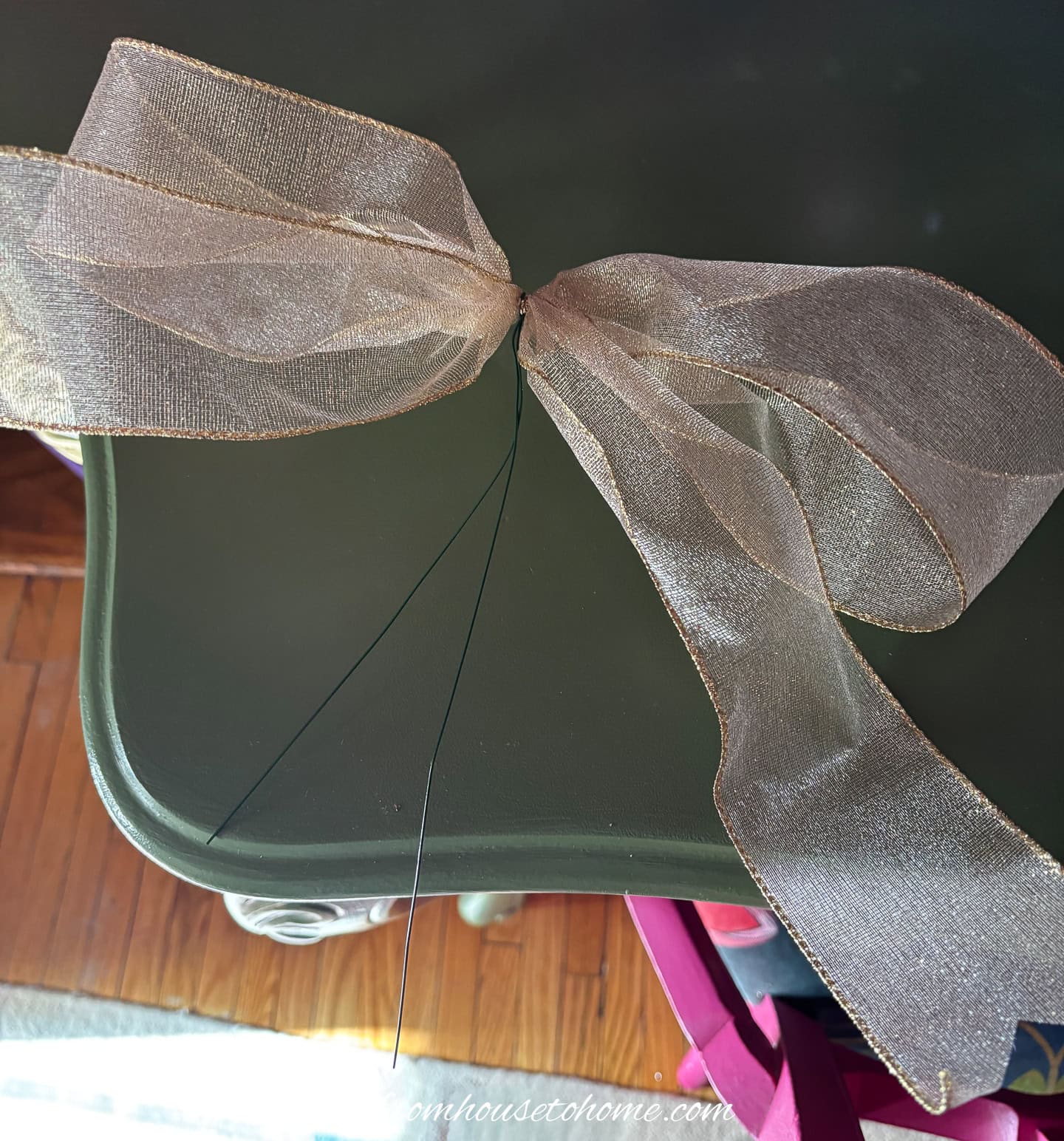 A gold bow tied in the middle with florist wire