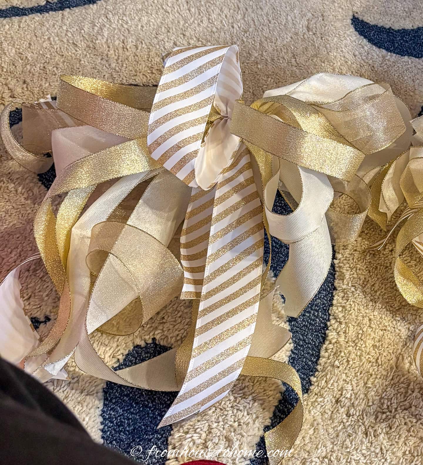 A large white and gold bow to be used as part of a Christmas tree topper
