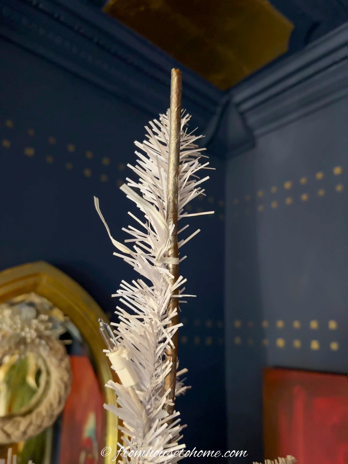 The top of an artificial Christmas tree being reinforced with a stake so it can hold the tree topper