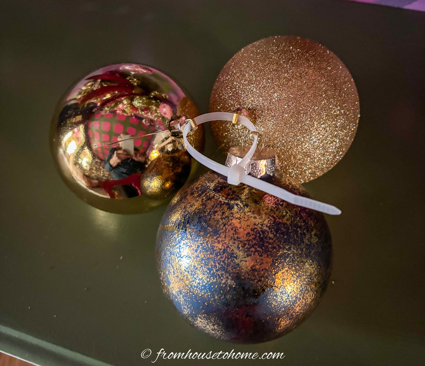 A cluster of Christmas ornaments tied together with a zip tie