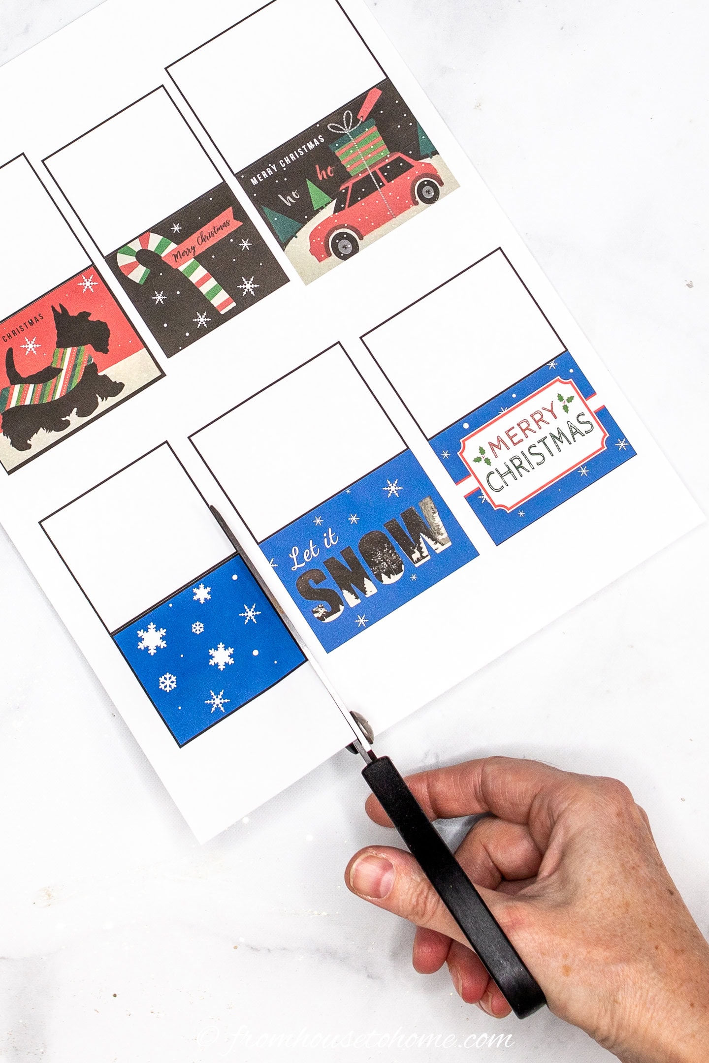 Printable Christmas gift tags being cut out with scissors