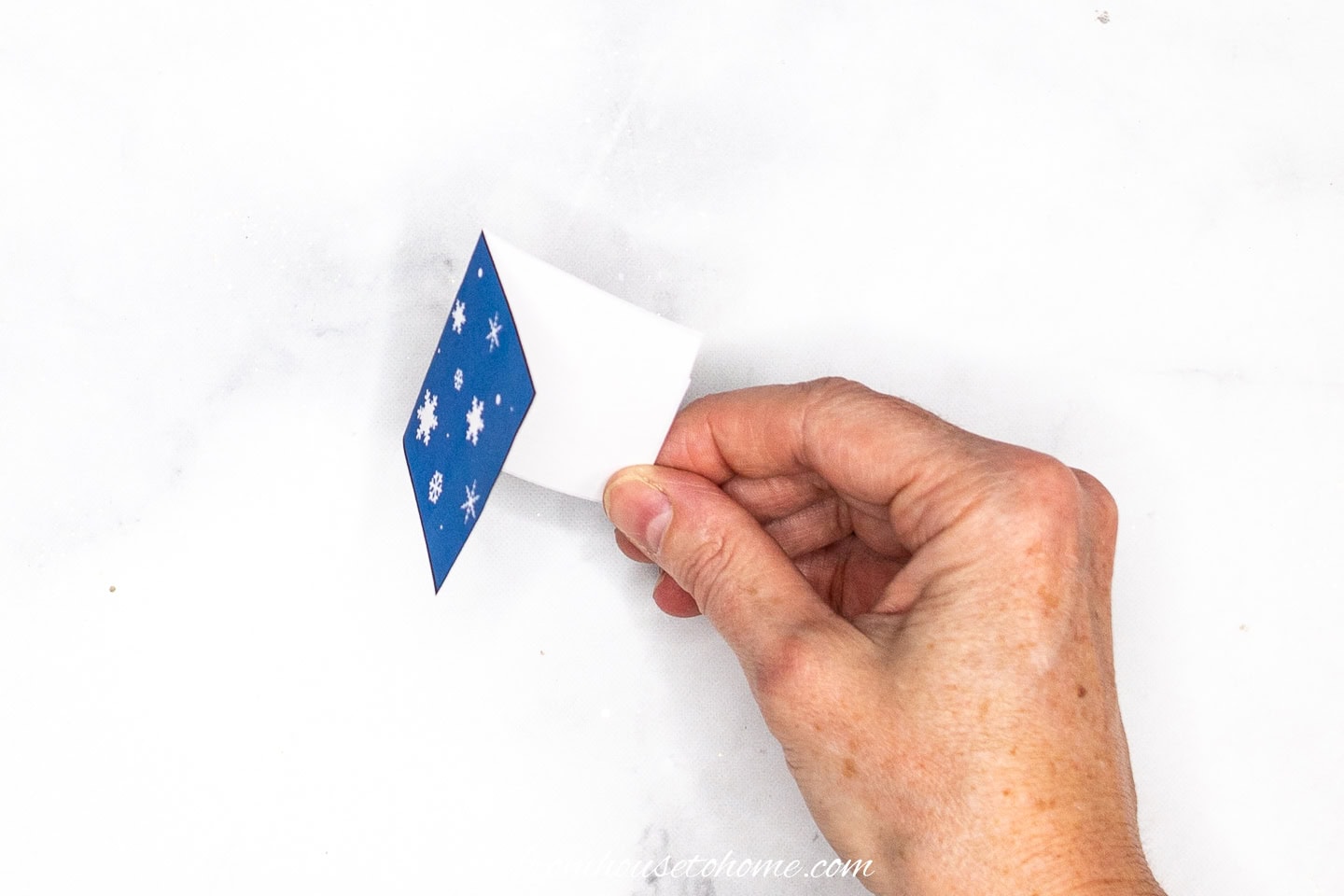 A folded Christmas gift tag from the side